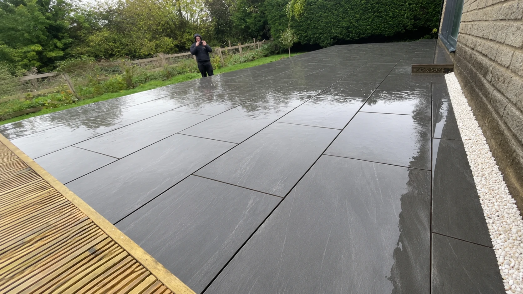 Completed dark porcelain patio beside timber decking