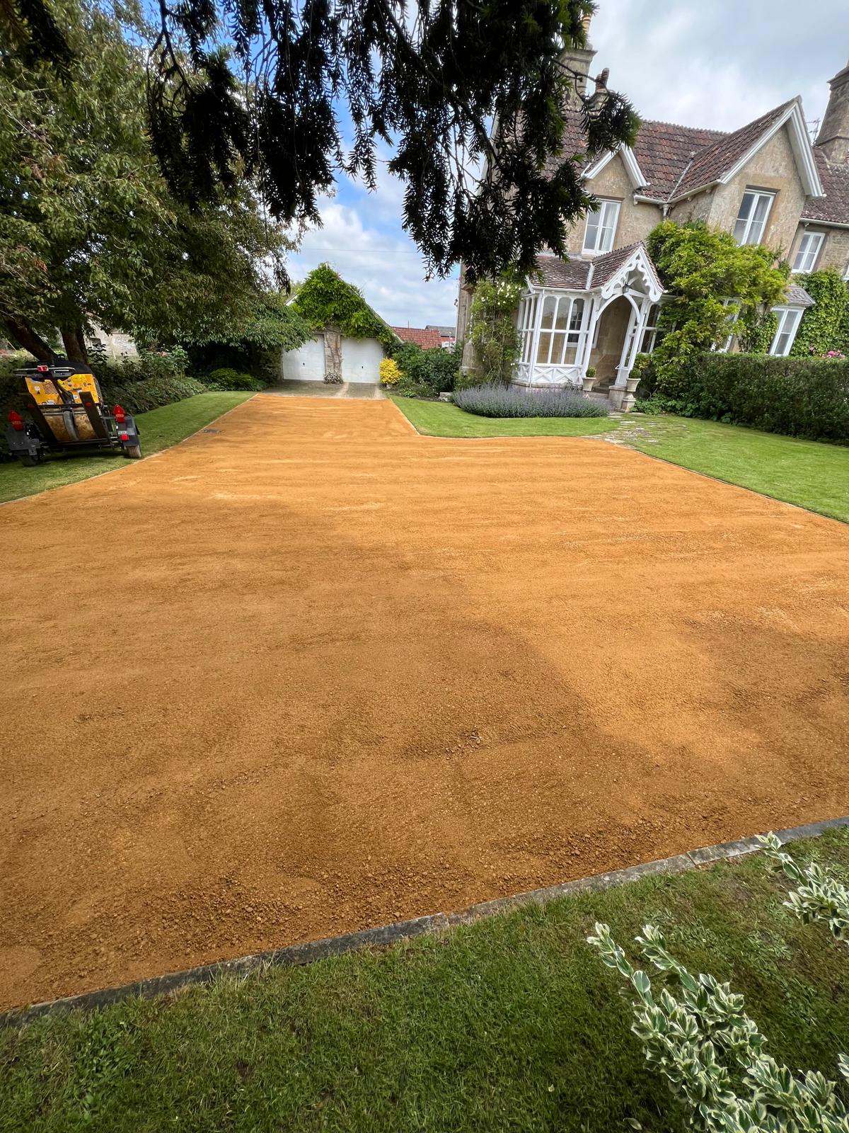 Golden gravel driveway curving around a country property